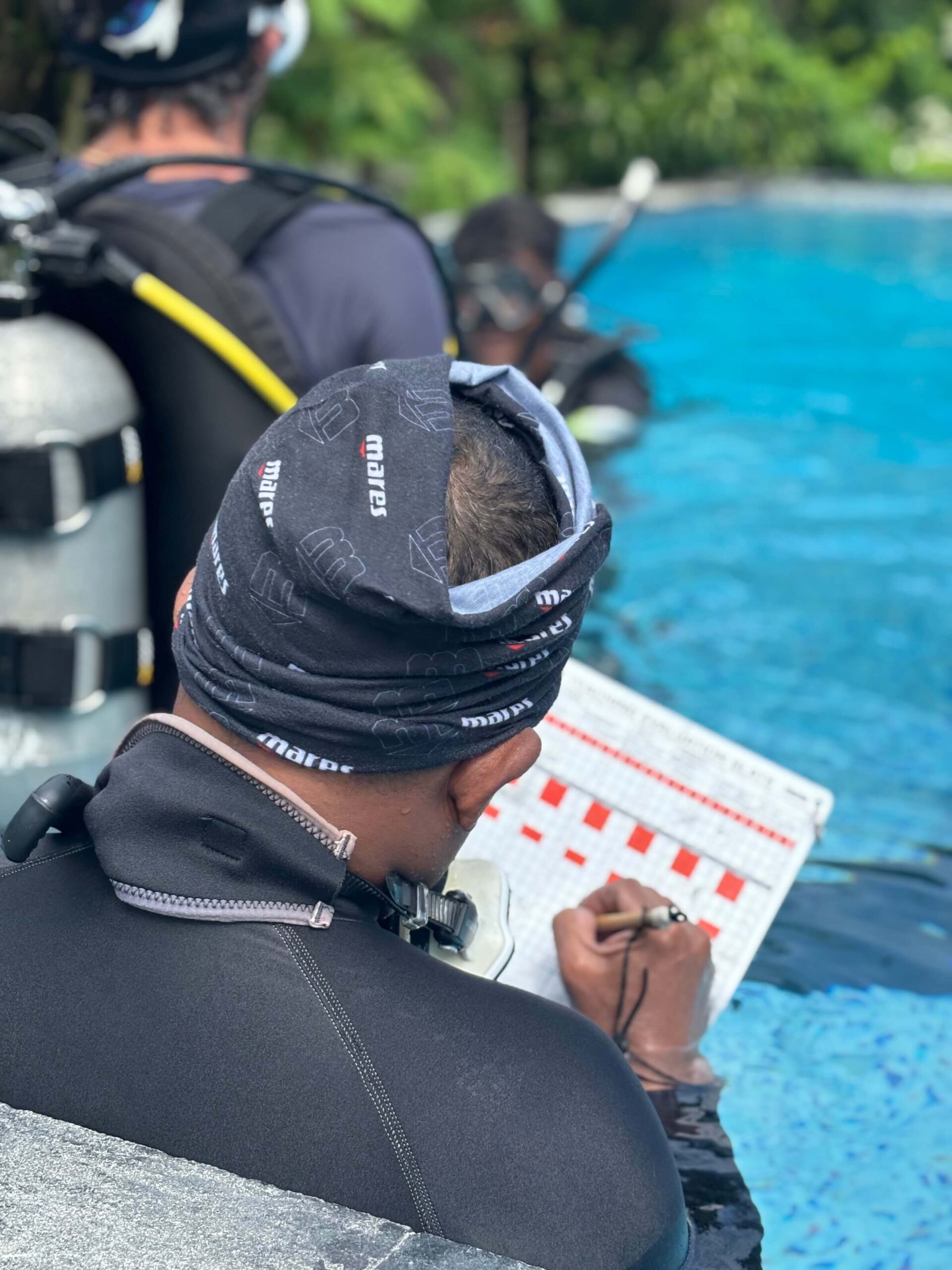 scuba instructor course Bali candidate using training slate during pool session